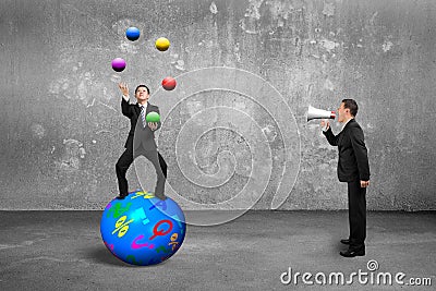 Boss using speaker yelling businessman balancing on sphere juggling balls Stock Photo