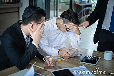 Boss is very angry and shouted to employee for reported sales decrease, employee is stressed and put hands on his head Stock Photo