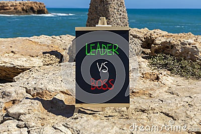 Boss vs leader symbol. Concept words Boss vs versus leader on beautiful black chalk blackboard. Beautiful stone sea sky background Stock Photo