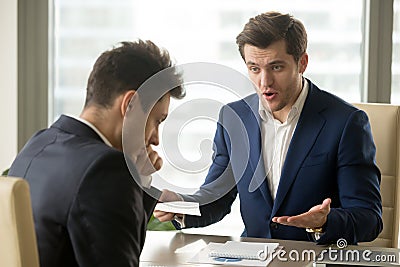 Boss yelling at employee for missing deadline, bad work results Stock Photo