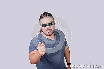 A bossy and belligerent man warns someone to back off. Pointing sternly with his finger. Isolated on a gray background Stock Photo