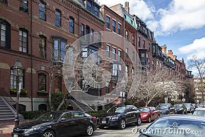 Boston, MA - April 8 2021: Rows of brownstone apartment brick buildings in Boston with front yards, trees and in Pennsylvania Editorial Stock Photo