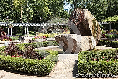 botanical garden with waterfall fountain rock structure bushes paths pathways. p Stock Photo