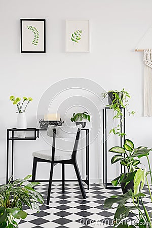 Botanical home office interior with a desk, chair and graphics on the wall. Real photo Stock Photo