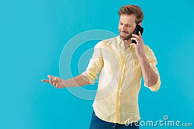 Bothered casual man disagreeing on his phone and gesturing Stock Photo