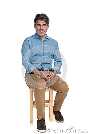 Bothered casual man looking forward and holding his hands together Stock Photo