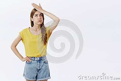 Bothered and pressured good-looking female feeling troubled and loaded with work making facepalm gesture exhaling and Stock Photo