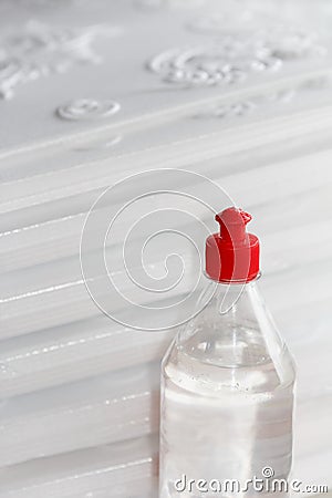 Bottle with acrylic, versatile glue designed for repair work, stands against the background of pressed foam plates for ceiling Stock Photo