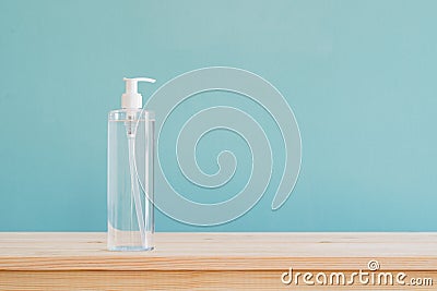 Bottle alcohol gel on brown wood desk and blue wallpaper textured background with copy space Stock Photo