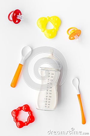 Bottle with breastmilk and infant formula powdered healthy food, spoons and bib on white background top view Stock Photo
