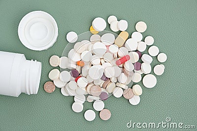 Bottle and a bunch of expired pills green background Stock Photo