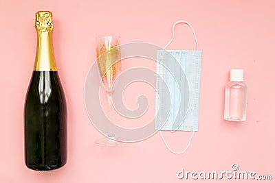 Bottle of champagne face mask hand sanitizing gel and glasses with gold glitter on pink background. Party decor. Christmas, Stock Photo