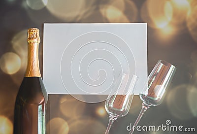 Bottle of champagne and two empty glasses with empty card for your notes. Stock Photo