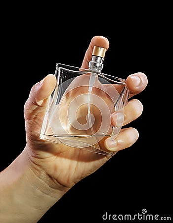 Bottle of cologne in a hand at the man Stock Photo