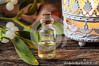 A bottle of essential oil with fresh mistletoe twigs Stock Photo