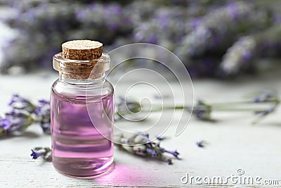 Bottle with essential oil and lavender flowers on wooden table. Space for text Stock Photo