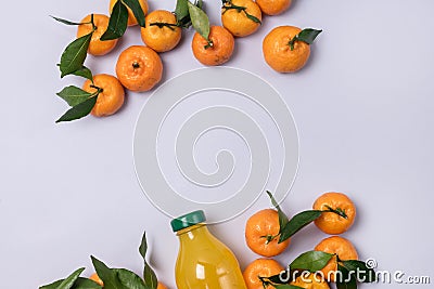 Bottle of Fresh Tangerine Juice with Ripe Tangerines Leaves Healthy Detox Drink Top View Blue Background Horizontal Stock Photo