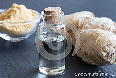 A bottle of ginger essential oil with fresh and dried ginger Stock Photo