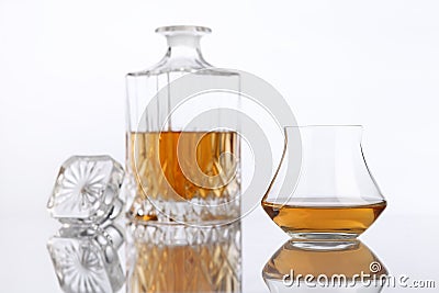 Bottle and glass of brandy on a white table Stock Photo