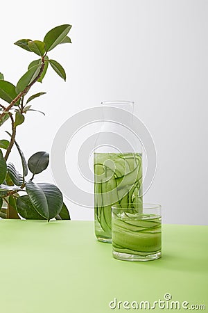 Bottle and glass with drink made of sliced cucumbers and plant Stock Photo