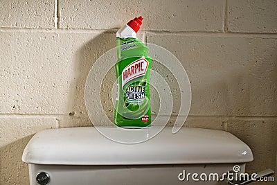 Bottle of Harpic toilet cleaner sat on top of a toilet cistern Editorial Stock Photo