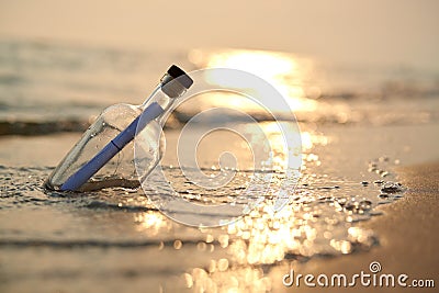 Bottle with a message on sea or ocean beach. Hope concept Stock Photo