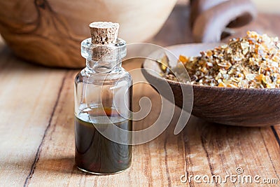 A bottle of myrrh essential oil with myrrh in the background Stock Photo
