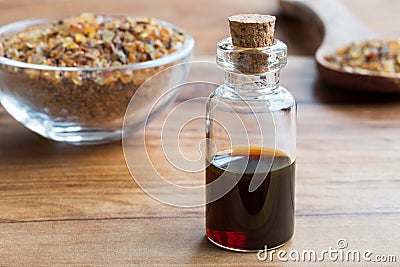A bottle of myrrh essential oil with myrrh resin in the background Stock Photo