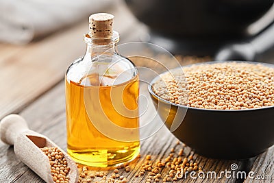 Bottle of natural mustard oil and bowl of whole grain mustard Stock Photo