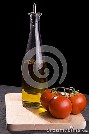 Bottle of oil and red tomatoes Stock Photo