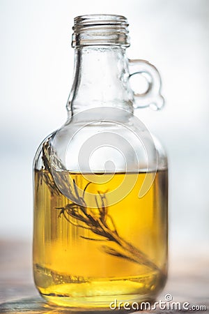 Bottle of olive oil with green rosemary sprig Stock Photo