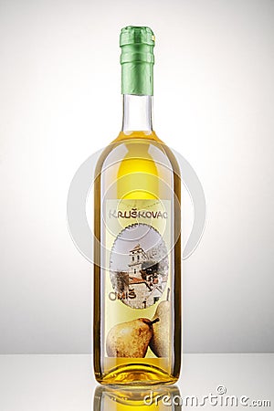 Bottle of pear flavored rakija isolated on gradient background produced in Omis, Croatia. Editorial Stock Photo