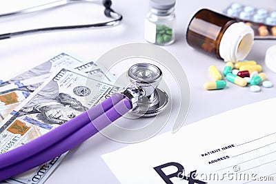 Bottle of pills, dollars banknotes and stethoscope lying on cardiogram chart closeup. medical costs and healthcare Stock Photo