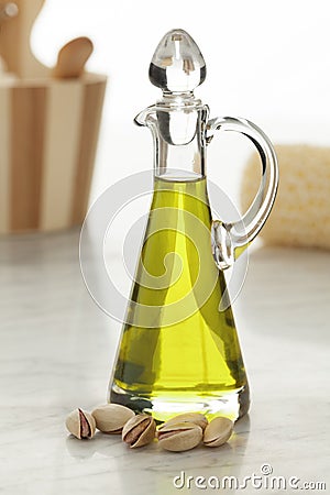 Bottle with pistachio oil and unshelled nuts Stock Photo