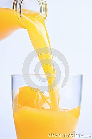 Bottle pouring Orange juice over glass Stock Photo