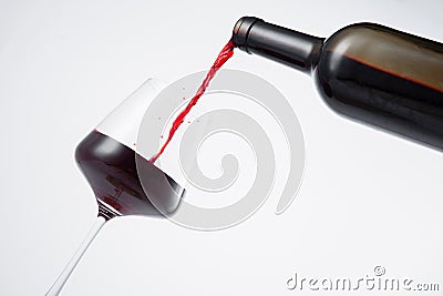 Bottle of red wine poured into the wine glass, on white background Stock Photo