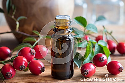 A bottle of rosehip seed oil on a wooden table Stock Photo