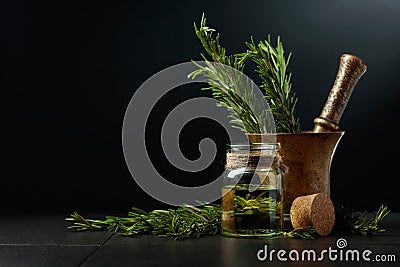 Bottle of rosemary aromatherapy oil extract with fresh rosemary branches Stock Photo