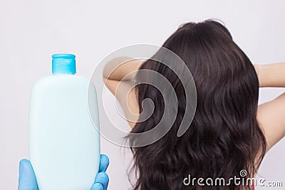 Bottle with shampoo on the background of a girl with lush beautiful hair, copy space Stock Photo