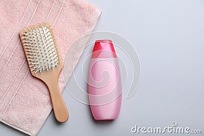 Bottle with shampoo, towel and brush on color background, flat lay. Stock Photo