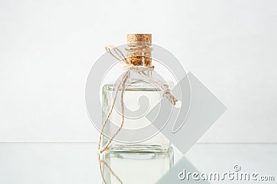 Bottle with transparent liquid and empty label on the light back Stock Photo