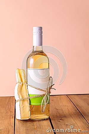 A bottle of white wine with a tied piece of cheese. Suitable food concept, couple. Creative. Stock Photo