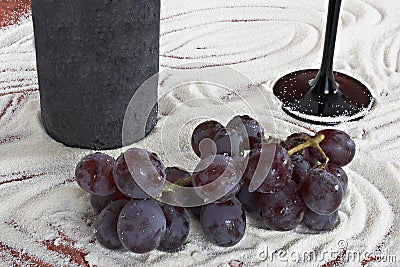 Bottle of wine with a beaker and bunch of grapes Stock Photo