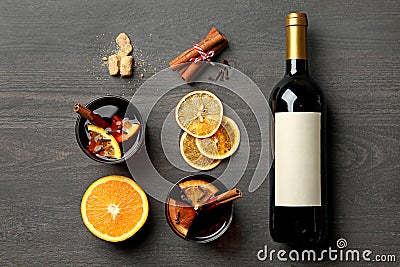 Bottle of wine, cups of mulled wine and ingredients on wooden background Stock Photo