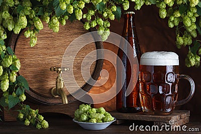 Bottled and unbottled beer with barrel and fresh hops Stock Photo