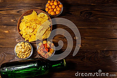 Bottles of beer and various snacks for beer on wooden table Stock Photo