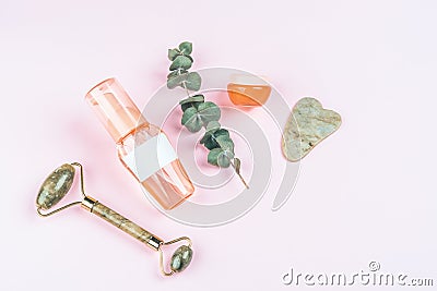 Bottles with care cosmetics, massager and scraper on pink background Stock Photo