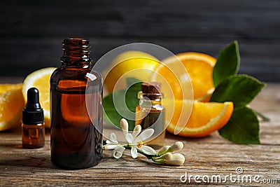 Bottles of citrus essential oil on wooden table. Space for text Stock Photo