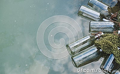 Bottles connected with notes inside float by the lake. Quests, games, adventures. Stock Photo