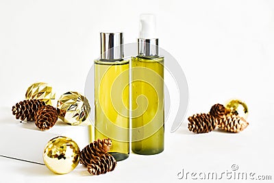 Bottles cosmetic product on a white background with golden Christmas balls, fir cones. SPA natural beauty products. Natural beauty Stock Photo